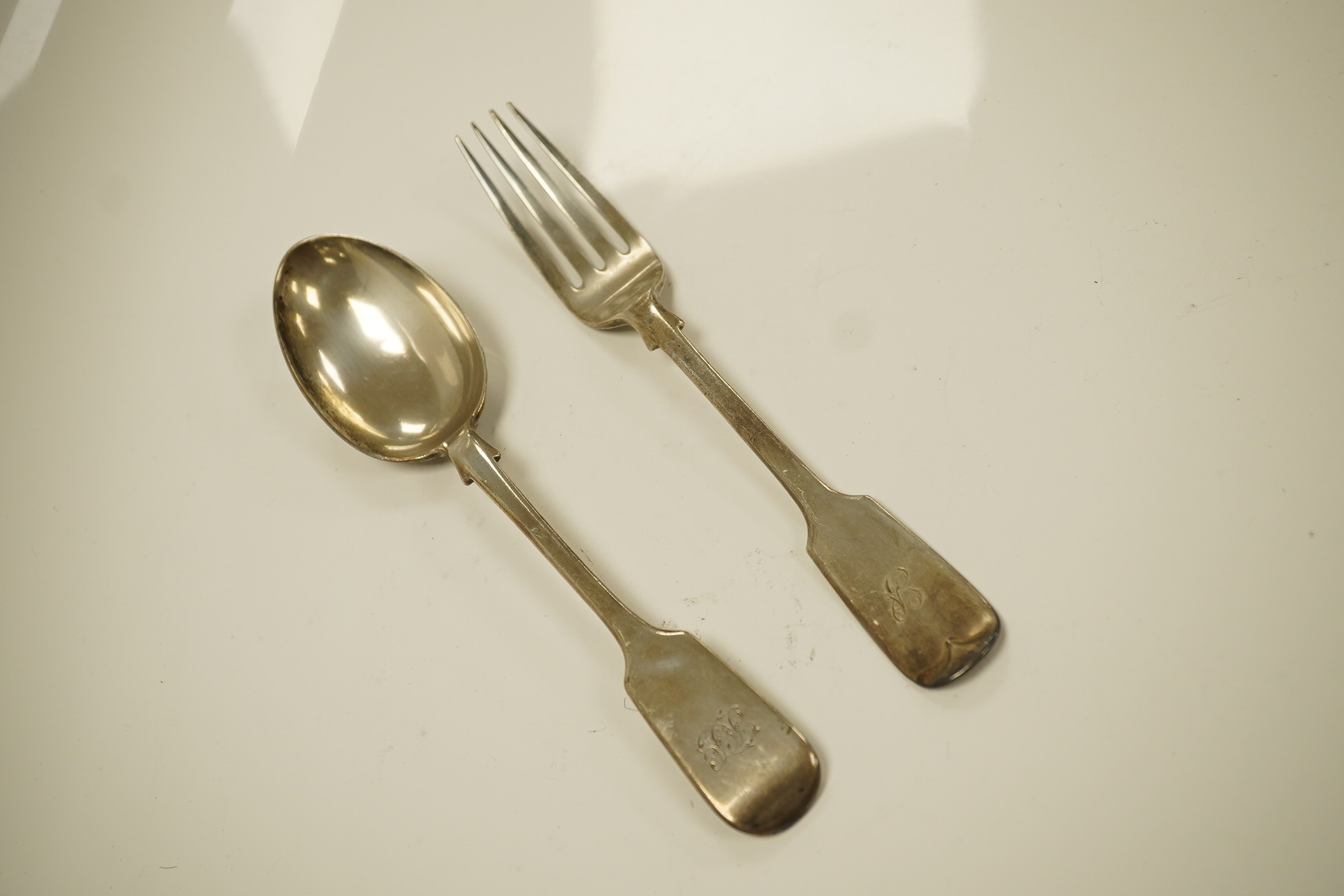 Twenty three items of mainly 19trh century silver fiddle pattern flatware, various dates and makers and a small group of assorted silver and white metal flatware, including Tiffany spoon, 39.8oz. Condition - poor to fair